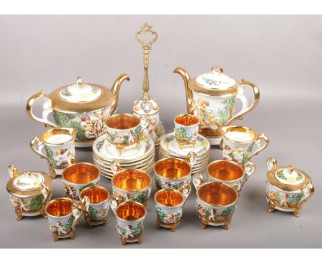 A collection of capodimonte teawares with gilt and cherubs decoration to include teapot, cup &amp; saucers, coffee pot, cream