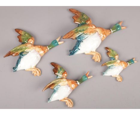 Four ceramic Beswick flying ducks.  Outstretched wing of the larger duck repaired.