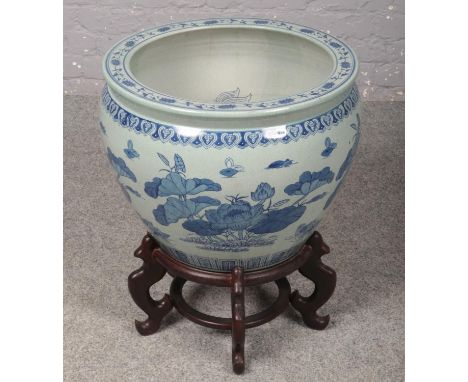 A large decorative oriental blue &amp; white ceramic bowl on wooden stand. (66cm x 55cm on stand)  
