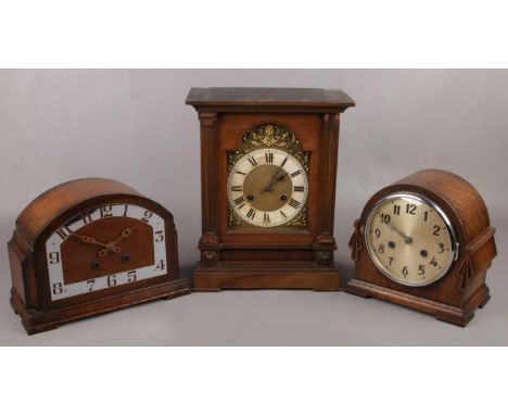 Two carved oak dome top mantel clocks along with a larger mantel clock with gilt dial.  