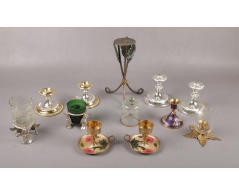 A selection of metal and glass candle stick holders to include, a pair of brass candle stick holders decorated with flowers a