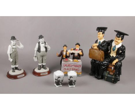A group of Laurel &amp; Hardy ceramic figures, sat on suitcases, to include salt &amp; pepper pots  Hardy broken off base