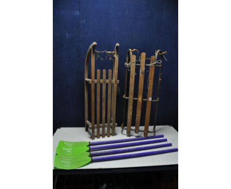 A VINTAGE TUBULAR METAL SLEDGE and a vintage Davos sledge (with some woodworm will need to be treated) and two pairs of plast