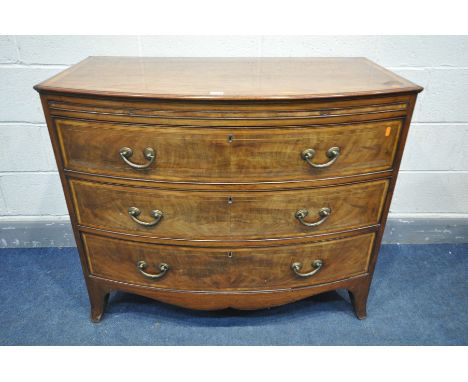 A GEORGIAN MAHOGANY AND CROSSBANDED BOWFRONT CHEST OF THREE LONG DRAWERS, with a brushing slide, brass handles, on outsplayed
