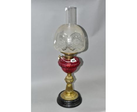 A LATE VICTORIAN BRASS BASED OIL LAMP, the domed acid etched clear and opaque shade above a cranberry reservoir, reeded and f