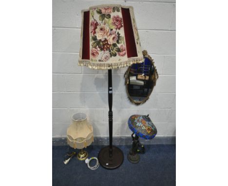 A TIFFANY STYLE FIGURAL STANDARD LAMP (condition:-broken at arm, see image) along with an ornate brass oval wall mirror, a ma