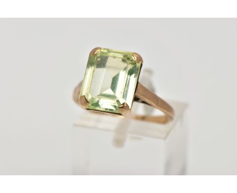 A 9CT GOLD DRESS RING, designed with a four claw set, rectangular green stone assessed as spinel, openwork gallery, plain pol