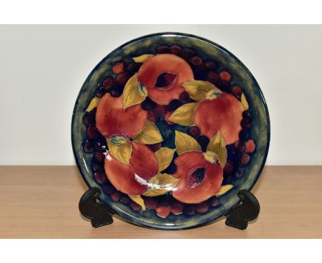 A MOORCROFT POTTERY SHALLOW BOWL, the interior decorated with a pomegranate design on a mottled blue ground, the exterior wit