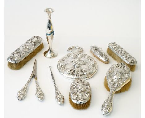 A Sterling silver mounted lady's eight piece dressing set, comprising; a hand mirror, a hairbrush, a small oval hairbrush, a 