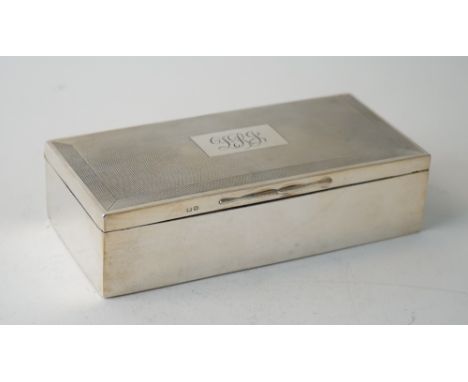 A silver rectangular table cigarette box, wooden lined within, the hinged lid with a monogram engraved rectangular cartouche 