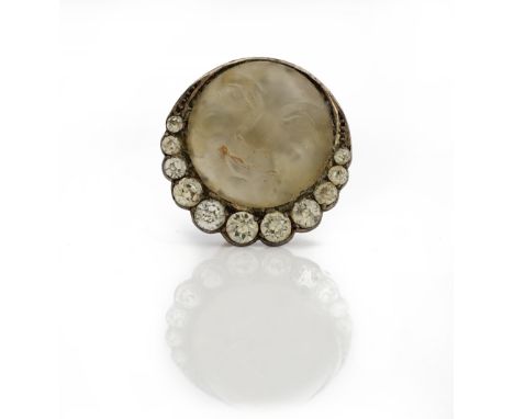 A rock crystal and colourless paste set brooch, the circular cabochon rock crystal carved to depict the Man in the Moon, in a