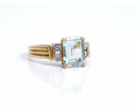 An 18ct two colour gold ring, claw set with a cut cornered rectangular step cut aquamarine, between two pairs of circular cut