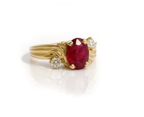 A gold, ruby and diamond three stone ring, claw set with an oval cut ruby between two circular cut diamonds, in a twist desig