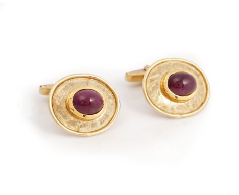 A pair of 9ct gold and cabochon ruby dress cufflinks, each mounted with an oval cabochon ruby to the front, on a textured ova