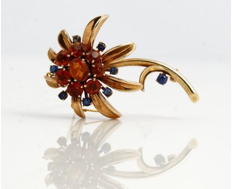 A 9ct gold, citrine and sapphire brooch, designed as a flower spray, mounted with the principal oval cut citrine to the centr