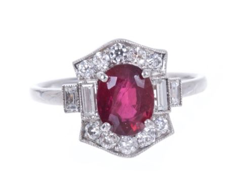 A ruby and diamond cluster ring with a central oval mixed cut ruby measuring approximately 7.65mm x 6.10mm x 3.85mm, flanked 