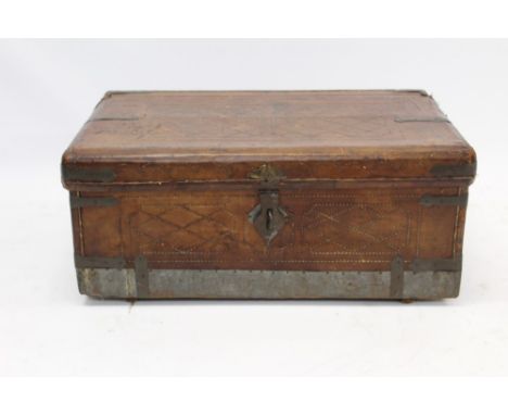 Antique Colonial leather and metal bound travelling trunk, sewn geometric ornament and fabric-lined interior, flanked by carr