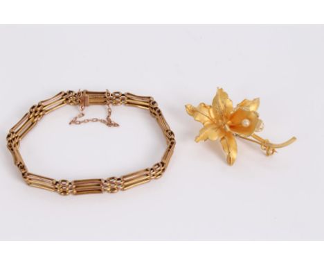 Edwardian yellow metal gate bracelet, together with a yellow metal orchid brooch, stamped 18k (2) CONDITION REPORT Gate brace