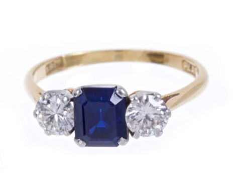 Sapphire and diamond three stone ring with a step cut sapphire measuring approximately 6.8mm x 5.0mm x 3.8mm, flanked by a br