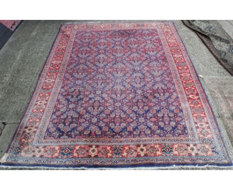 Large Persian carpet, the navy ground with allover angular floral meander motif within multiple borders, 365cm x 253cm