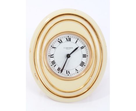 1980s Cartier alarm clock with circular white enamel dial and cream and gilt oval case with easel back and cabochon blue ston