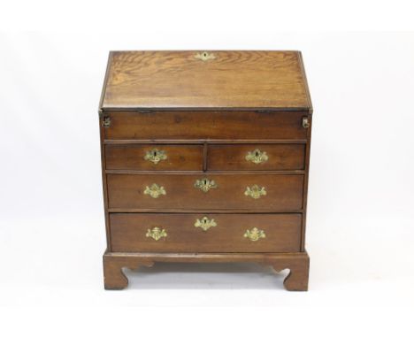 George II oak bureau, fall-front enclosing fitted stepped interior of short drawers and pigeon holes with well below and two 