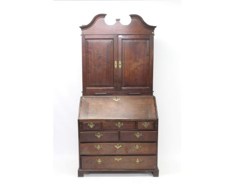 Early 18th century walnut bureau cabinet with shaped cornice and interior of adjustable shelves over short drawers, enclosed 