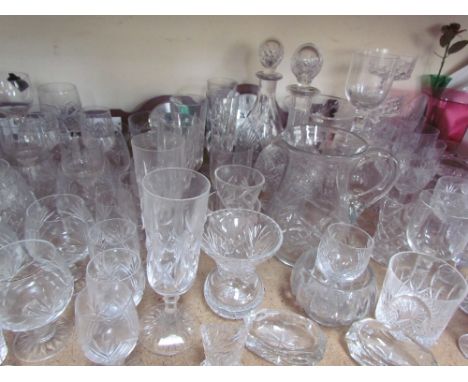 Glass decanters together with a large quantity of drinking glasses, cranberry glass jug, Royal Brierley glass vase, modern ba