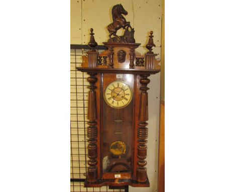 A walnut cased Vienna regulator type wall clock, the dial with Roman numerals and a brass pendulum