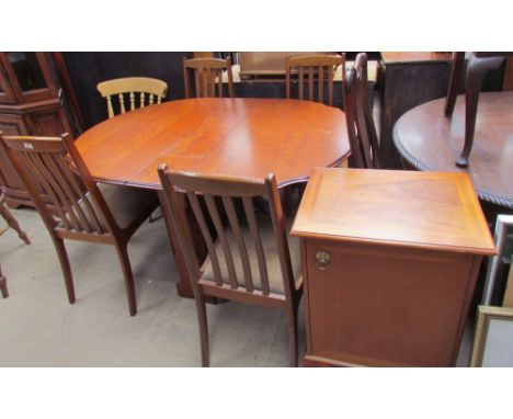 A reproduction walnut gate leg dining table together with four chairs and a music cabinet