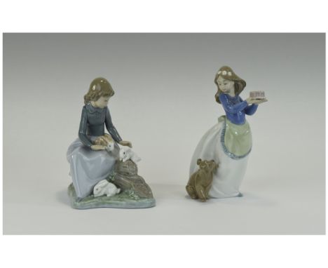 Nao by Lladro Figures ( 2 ) In Total. 1/ Young Girl - Sitting with Rabbits. 6.5 Inches High. 2/ Young Girl Holding a Cake wit