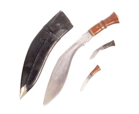 A WWII Second World War period Gurkha Regiment Kukri Knife and scabbard. The knife having a shaped mahogany and brass handle,