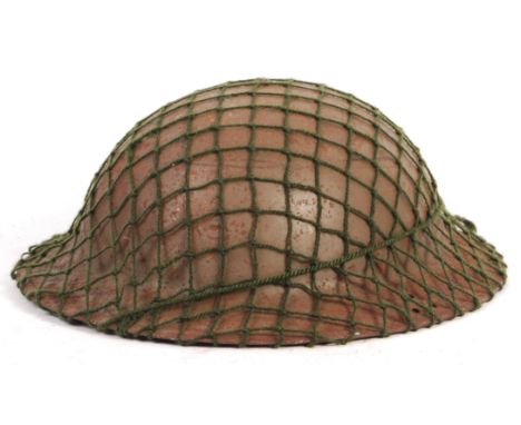 An original WWII Second World War c1940 British Army steel brodie combat helmet. Dated 1940 to the liner. Chin strap named to