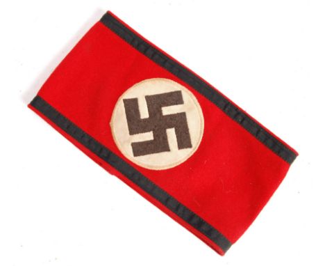 A 20th Century German Nazi Third Reich style armband having a red felt band with black bands to top and bottom and a round pa