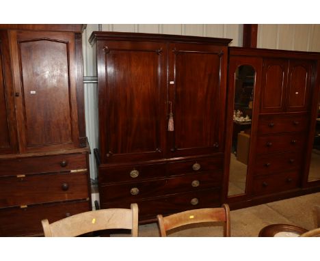 A Georgian mahogany linen press converted to a hanging wardrobe, panelled door above two dummy drawers with single long drawe