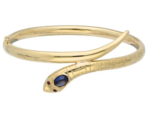 14K Yellow gold snake bracelet. Set with a cabochon cut synthetic sapphire (approx. 6.61 x 4.80 mm) and two garnets as eyes. 