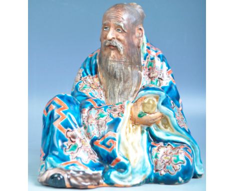 An antique 19th Century Chinese Oriental ceramic figure of an elder in a seated position adorned&nbsp;with garments having de