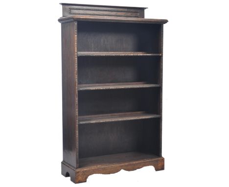 An antique 19th Century Victorian Arts and Crafts carved oak open upright library bookcase having a carved gallery pack piece