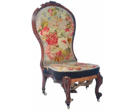 An antique 19th Century Victorian English rosewood and walnut nursing chair / bedroom chair of low spoon back form having a d
