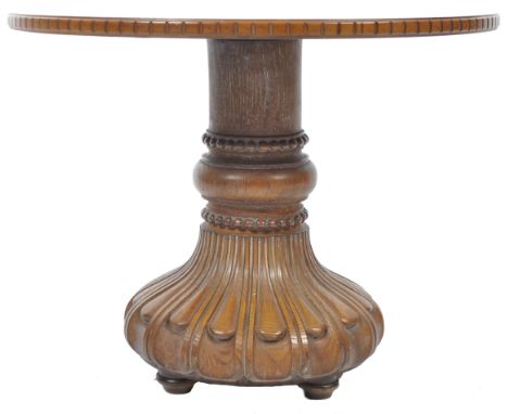 An antique early 20th Century English coffee / side occasional lamp table of walnut and oak construction. The circular walnut