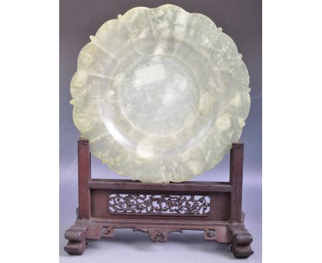 An antique 19th Century or earlier Chinese Oriental jade hand carved plate of scalloped circular form with lightly carved flo