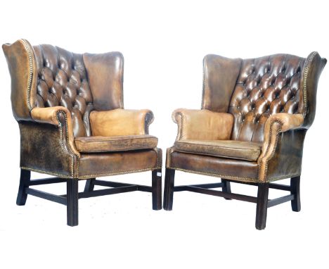 A pair of 20th Century Queen Anne / Georgian style leather wingback armchairs fireside wing arm chairs having a Chesterfield 