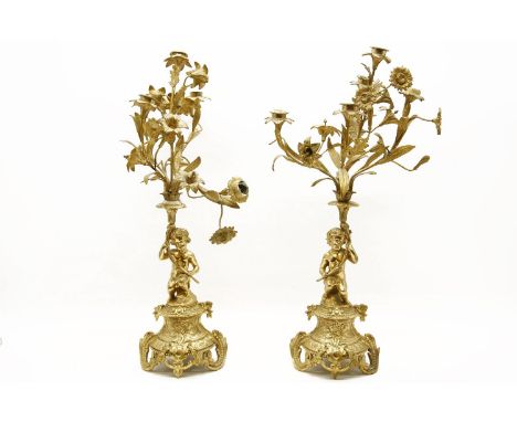 A pair of 19th century ormolu candelabra supported by cherubs