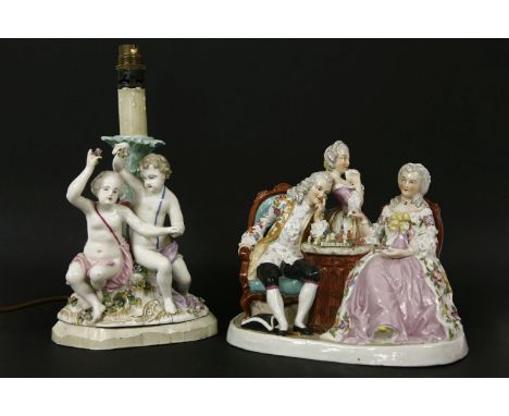 A late 19th century early 20th century porcelain figural group in the form of a gentleman and his two ladies playing chess, m