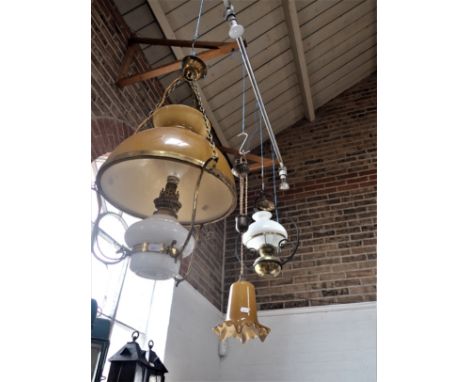 A VICTORIAN STYLE HANGING OIL LAMP converted to electricity, with a glass shade, 52cm high approx, and two further of similar