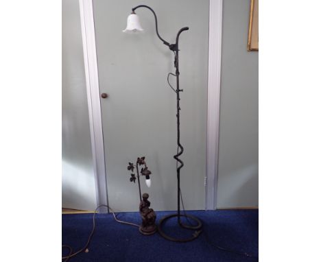 AN ARTS AND CRAFTS STYLE STANDARD LAMP in wrought iron of hammered finish, with small glass shade, and a reproduction Belle E