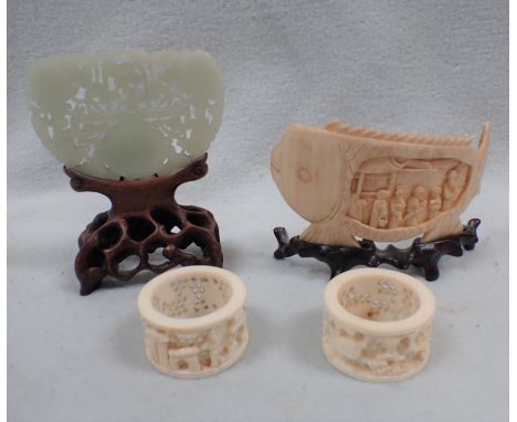 A SMALL CHINESE JADE PLAQUE ON A WOODEN STAND a bone carving of a fish, and two ivory napkin rings (4)