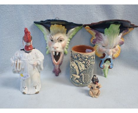 A PAIR OF CONTINENTAL FAIENCE WALL BRACKETS, GROTESQUE HEADS 16cm high, a nodding head anthropomorphic chicken figure, a bisq