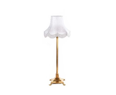 EDWARDIAN CORINTHIAN BRASS PILLAR STANDARD LAMP ON A SQUARE BASE AND FOUR PAD FEET. COMPLETE WITH SILVER SILK SHADE. HEIGHT: 