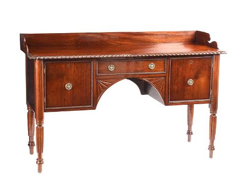 GEORGIAN MAHOGANY GALLERY BACK SIDEBOARD FITTED WITH ONE DRAWER AND TWO CUPBOARDS WITH BRASS RING HANDLES.RAISED ON FLUTED LE